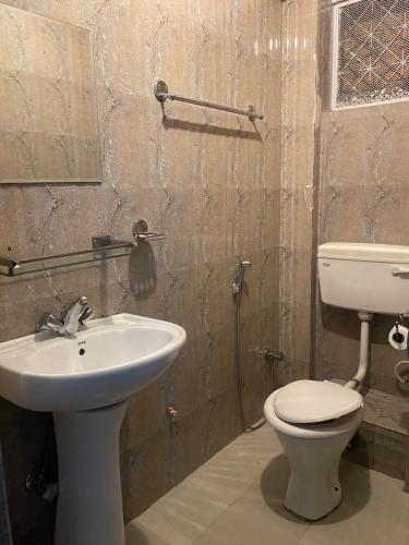 a bathroom with a white toilet and a sink at Bag Packer's Lodge in Kathmandu