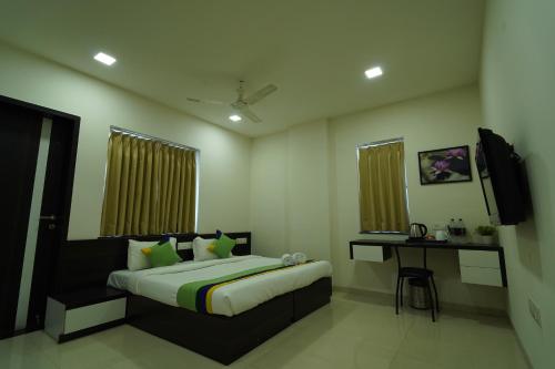 a bedroom with a bed and a desk in it at Excellent Homes in Nashik