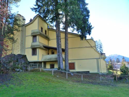 una casa amarilla con dos árboles delante de ella en Monolocali Alberti - Silvana, en Madonna di Campiglio