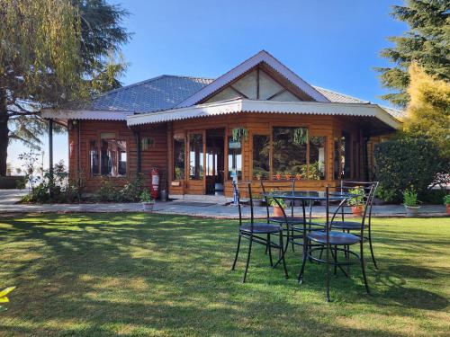 a table and chairs in front of a house at The Chalets Naldehra in Shimla