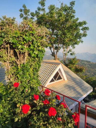 a house with a roof and red roses at The Chalets Naldehra in Shimla