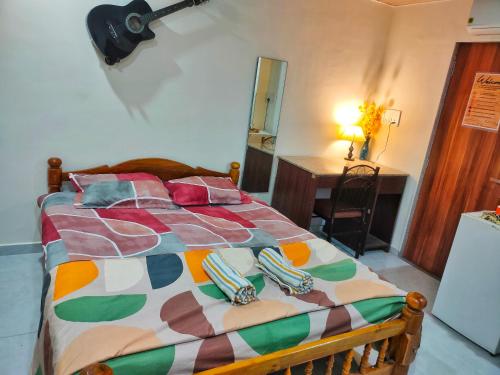 a bed with a colorful comforter in a room at Ebony Room - AC, Kitchenette, Ensuite, Independent Homestay in Mumbai
