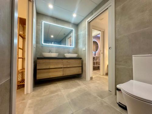 a bathroom with two sinks and a mirror at Sea Views Sanatori Beach Deluxe, Barcelona in Calafell