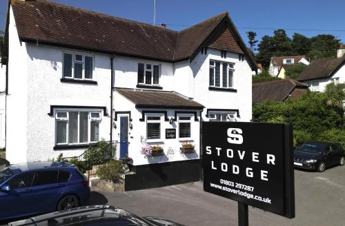 a sign in front of a house with a sucker lodge at Stover Lodge in Torquay