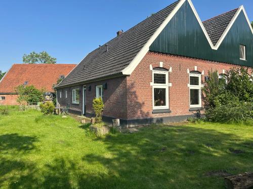 a red brick house with a green roof at Vakantiewoning Het leeft in je in Hengelo