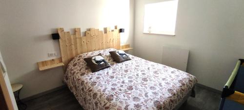 ein Schlafzimmer mit einem Bett mit einem hölzernen Kopfteil in der Unterkunft AU MENILOIS entre Montagne et Forêt in Cornimont