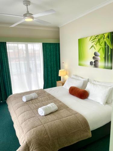 a bedroom with a large bed with two pillows on it at City Heart Motel Warrnambool in Warrnambool
