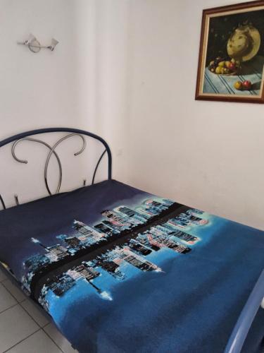 - un lit avec une couverture bleue et une photo sur le mur dans l'établissement Les pieds dans l'eau, à Narbonne