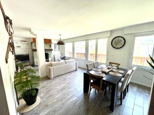 une salle à manger et un salon avec une table et des chaises dans l'établissement Appartement unique en plein cœur du vieux village, à Saint-Lary-Soulan