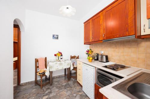 a kitchen with a table and a small table with a table at Kosmas Apartments in Roda