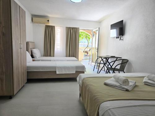 a hotel room with two beds and a table at Apartments Duga Ulcinj in Ulcinj