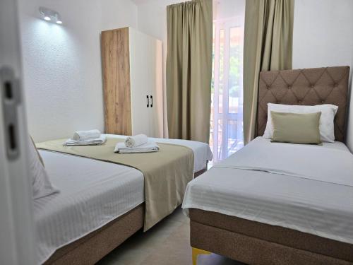 a hotel room with two beds and a window at Apartments Duga Ulcinj in Ulcinj