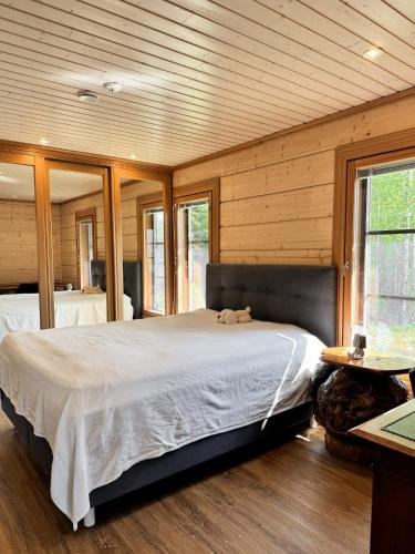 Un dormitorio con una cama grande en una habitación con paredes de madera. en AureenHelmi, en Aurekoski