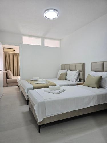 a room with three beds and a couch at Apartments Duga Ulcinj in Ulcinj