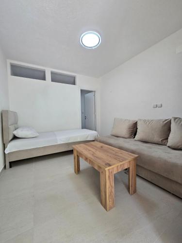 a living room with a couch and a wooden table at Apartments Duga Ulcinj in Ulcinj