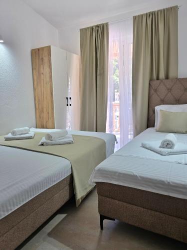 two beds in a room with a window at Apartments Duga Ulcinj in Ulcinj