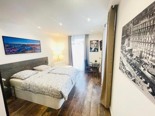 une chambre avec un lit et un tableau au mur dans l'établissement Le Pinson Mignon Cannes Carre d Or, à Cannes