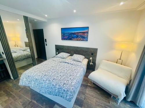 une chambre avec un lit, une chaise et un miroir dans l'établissement Le Pinson Mignon Cannes Carre d Or, à Cannes