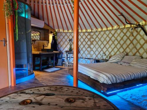 une chambre avec un lit dans une yourte dans l'établissement Yourte en pleine nature, 