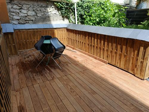 une terrasse en bois avec une chaise sur une clôture en bois dans l'établissement La Colombière, à Lourdes
