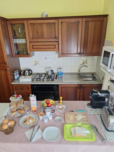a kitchen with a table with plates of food on it at B&B Casa Piras IUN3880 in Barùmini