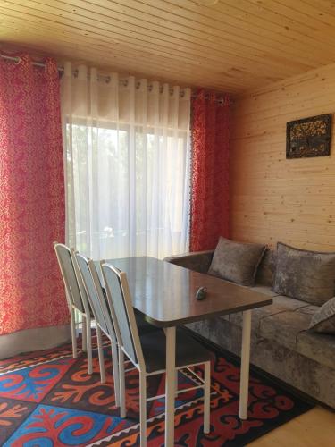 a dining room with a table and chairs and a couch at Cottage Diamond in Dolinka