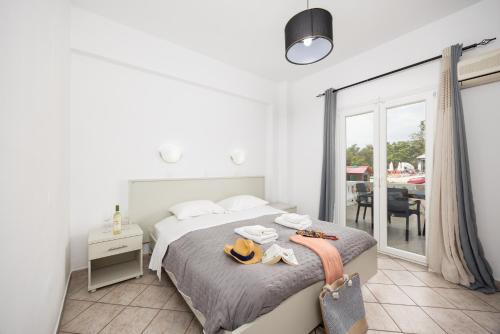 a bedroom with a bed and a balcony with a table at Kosmas Apartments in Roda