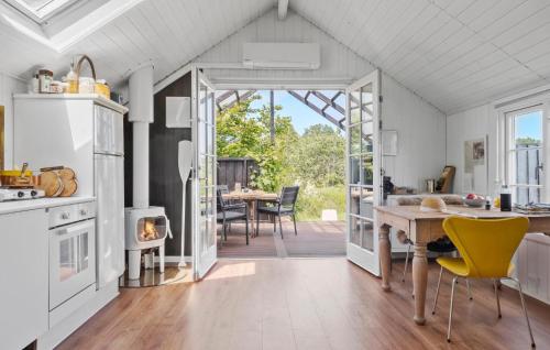 a kitchen and dining room with a table and yellow chairs at 2 Bedroom Gorgeous Home In Glesborg in Glesborg
