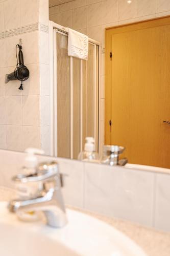 a bathroom with a sink and a mirror at Pension Schlossberg in Mittersill