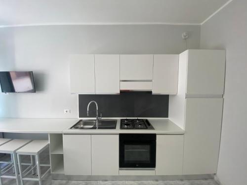 a white kitchen with white cabinets and a sink at Annarè Home in Vasto