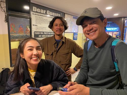 three people posing for a picture with their cell phones at Bag Packer's Lodge in Kathmandu