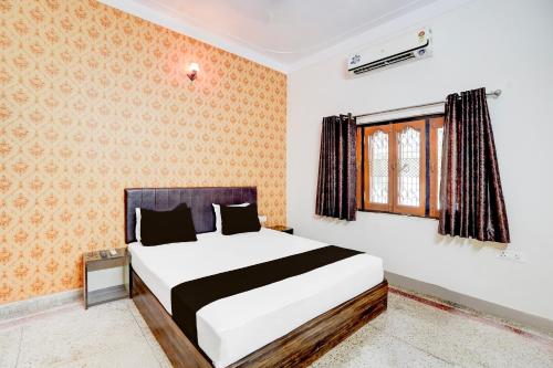 une chambre avec un lit et une fenêtre dans l'établissement HOTEL O Happy Inn, à Jabalpur