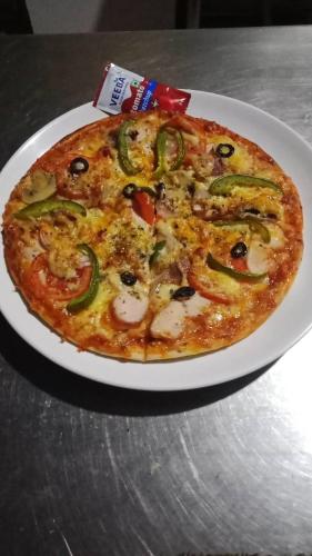 a pizza on a white plate on a table at Bag Packer's Lodge in Kathmandu
