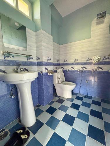 a blue and white bathroom with a sink and a toilet at Fewa Homestay and Retreat in Pokhara