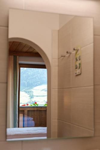 a mirror in a bathroom with a view of a window at Pension Schlossberg in Mittersill