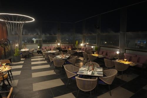 a restaurant with tables and chairs at night at Ramada Encore by Wyndham Chandigarh Zirakpur in Zirakpur