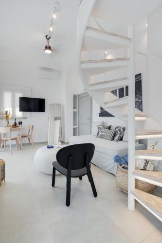 una habitación blanca con una silla negra y una cama en SantoView Suites, en Vourvoúlos