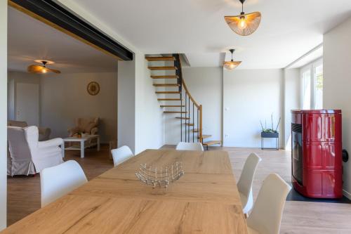 une salle à manger avec une table en bois et des chaises blanches dans l'établissement Gîte dans un village Aveyronnais, à Lunac