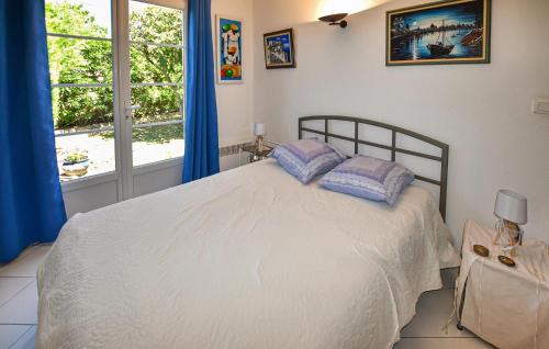 a bedroom with a bed with blue curtains and a window at Stunning Home In Morières-Lès-Avignon in Morières-lès-Avignon