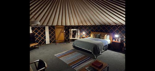 a bedroom in a yurt with a bed and a rug at the hole in the rock yurt in Cape Foulwind