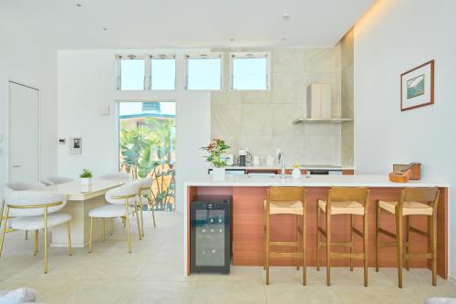 a kitchen with a counter and a table and chairs at 愛犬と泊まれるvilla,温水プール,サウナ,BBQ,ドッグラン,海まで徒歩5分,千葉 一宮---THE NALU --- in Ichinomiya