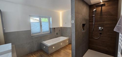a bathroom with a bath tub and a window at Ferienwohnungen Martlhof in Leogang
