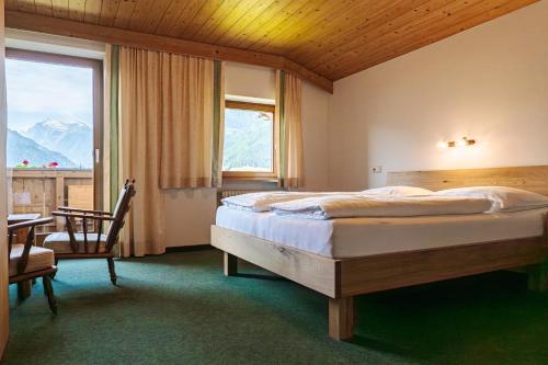 a bedroom with a bed and a desk and a window at Pension Schlossberg in Mittersill