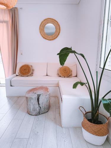 a living room with a bench and a plant at The White Rose Hotel in Poros
