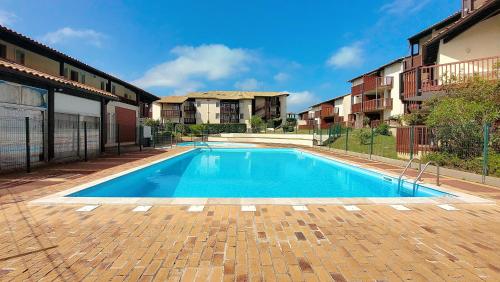 une piscine au milieu d'un immeuble dans l'établissement V-Landes 10-Joli petit appartement proche lac marin dans résidence avec piscine, à Vieux-Boucau-les-Bains