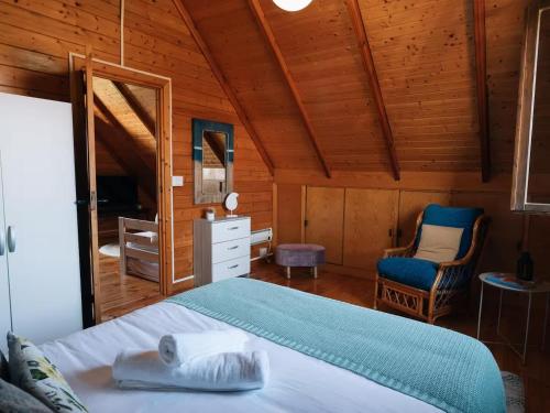 una camera da letto con un letto e una sedia in una stanza di Casa de campo entre viñedos a Laguardia