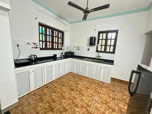a kitchen with white cabinets and a ceiling fan at 4bhk Family Villa near beach-4K-6k per night in Colva