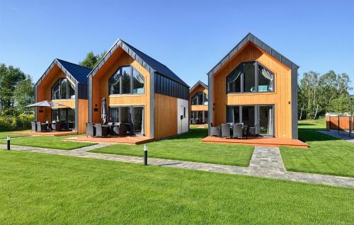 a large building with windows on a green lawn at Cozy Home In Bialogora With Wifi in Białogóra