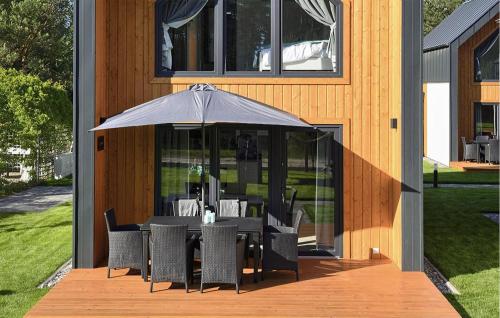a table and chairs with an umbrella on a deck at Nice Home In Bialogora With Wifi in Białogóra