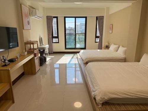 a hotel room with two beds and a flat screen tv at 夏米旅宿 in Lugang